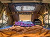 Interior of Vagabond XL Rooftop Tent with sheets, lights, and skylight